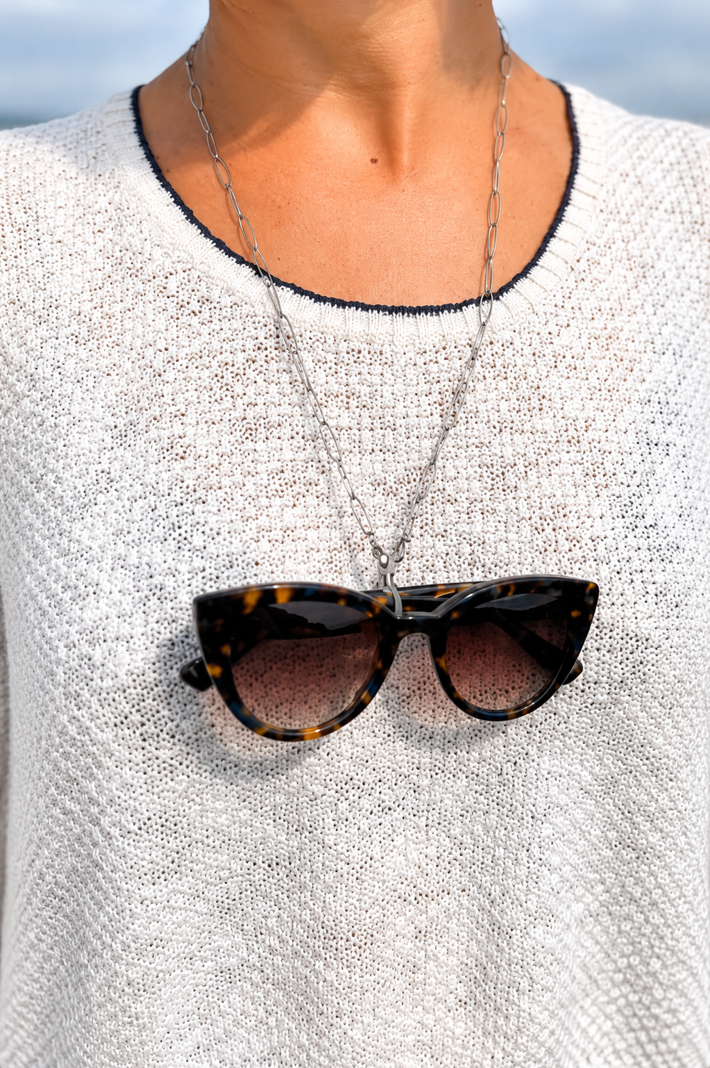 Henriette portée en chaîne de lunettes, lunettes écaille sur un pull écru, JACQUAND